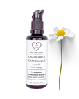 Miron violet glass bottle of chamomile face oil displayed with a fresh chamomile flower on a white background, Dry Skin Love Chamomile 1% Bisabolol Face Oil for Sensitive Skin.