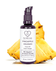 Miron violet glass bottle of pineapple face oil displayed with a fresh pineapple slice on a white background, Dry Skin Love Pineapple 10% Vitamin C Face Oil for Dry Aging Skin.